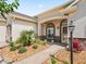 Inviting front entrance with stone accents, a covered porch, and manicured landscaping at 10977 Se 169Th Ln, Summerfield, FL 34491