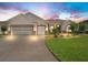 Charming single-story home featuring a well-manicured lawn, beautiful landscaping, and a spacious driveway at 10977 Se 169Th Ln, Summerfield, FL 34491
