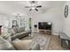 Spacious living room featuring modern furniture, a stylish rug, and abundant natural light at 10977 Se 169Th Ln, Summerfield, FL 34491