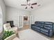 Comfortable living room featuring a ceiling fan, adjacent kitchen views, and a modern furniture set at 10977 Se 169Th Ln, Summerfield, FL 34491