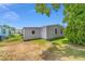 Side and back view of home with light gray siding and a spacious backyard at 1109 Paradise Dr, The Villages, FL 32159