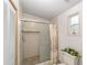 Bathroom featuring a glass-enclosed shower with floral curtains and tiled walls at 1109 Paradise Dr, The Villages, FL 32159