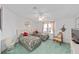 Cozy bedroom with twin beds, ceiling fan, and soft green carpet at 1109 Paradise Dr, The Villages, FL 32159
