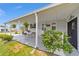 Inviting carport area featuring lush greenery and a cozy seating area leading to the front door at 1109 Paradise Dr, The Villages, FL 32159