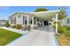 Attractive home with a covered carport, beautiful landscaping, and a long driveway with custom design at 1109 Paradise Dr, The Villages, FL 32159