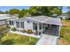 Inviting home with lush landscaping, decorative shutters, and a convenient covered carport at 1109 Paradise Dr, The Villages, FL 32159