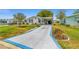 Charming home with a long driveway featuring a blue star design, beautiful landscaping, and a covered carport at 1109 Paradise Dr, The Villages, FL 32159