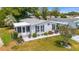 Beautifully landscaped home featuring a covered porch, black shutters, and manicured lawn at 1109 Paradise Dr, The Villages, FL 32159