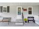 Charming front porch with inviting benches, decorative accents, and a welcoming ambiance at 1109 Paradise Dr, The Villages, FL 32159