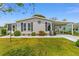 Charming single story home featuring green lawn, carport, landscaped garden, and decorative facade at 1109 Paradise Dr, The Villages, FL 32159
