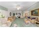 Spacious living room with a ceiling fan, a fireplace, and a seamless flow into the dining area at 1109 Paradise Dr, The Villages, FL 32159