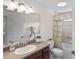 Bathroom features a bathtub with a curtain, a modern sink with cabinet storage, and tiled floors at 1140 Eureka Mill Run, The Villages, FL 32162