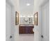 Bathroom with tiled floor, and sinks, and decorative framed art hung on the walls at 1140 Eureka Mill Run, The Villages, FL 32162