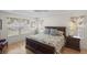 Bright bedroom boasts a ceiling fan, hardwood floors, and a comfortable bed with floral patterned bedding at 1140 Eureka Mill Run, The Villages, FL 32162