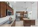 Modern kitchen with stainless steel appliances, wooden cabinets, and an island at 1140 Eureka Mill Run, The Villages, FL 32162