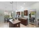 Open kitchen featuring an island, tile floors and dark wood cabinets at 1140 Eureka Mill Run, The Villages, FL 32162