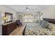 Spacious main bedroom with tray ceiling, hardwood floors and floral bedding at 1140 Eureka Mill Run, The Villages, FL 32162
