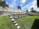 Landscaped backyard with a tiered retaining wall, vibrant greenery and a white fence providing a private outdoor space at 1268 Patterson Ter, Lake Mary, FL 32746