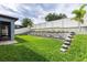 Beautifully landscaped backyard with lush green grass, steps, and a white fence at 1268 Patterson Ter, Lake Mary, FL 32746