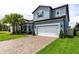 Inviting two-story home featuring a brick driveway, lush landscaping, and a spacious two-car garage at 1268 Patterson Ter, Lake Mary, FL 32746