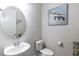 Cozy half bath features a pedestal sink, round mirror, and turtle-themed artwork at 1268 Patterson Ter, Lake Mary, FL 32746