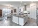 Kitchen featuring a granite island with seating, white cabinets, and an adjoining dining area with chandelier at 1268 Patterson Ter, Lake Mary, FL 32746