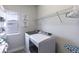 Well-lit laundry room with a modern washer and dryer, storage shelves, and a window at 1268 Patterson Ter, Lake Mary, FL 32746