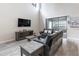 Living room features a high ceiling, a large sectional sofa, and a sliding glass door to the backyard at 1268 Patterson Ter, Lake Mary, FL 32746