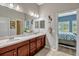 Bathroom boasts double sinks, modern fixtures, and a view into the primary bedroom at 13304 Magnolia Valley Dr, Clermont, FL 34711