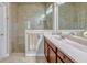 Bathroom featuring a glass enclosed shower with stone flooring and a vanity with a light marble countertop at 13304 Magnolia Valley Dr, Clermont, FL 34711