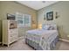 Bedroom with soft green walls, a patterned bedspread and a ceiling fan provides comfort at 13304 Magnolia Valley Dr, Clermont, FL 34711