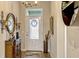 Inviting foyer with decorative mirror, cabinet, umbrella stand, and a bright front door with glass detail at 13304 Magnolia Valley Dr, Clermont, FL 34711