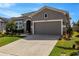 Charming home featuring a well-manicured lawn, beautiful landscaping, and a two-car garage at 13304 Magnolia Valley Dr, Clermont, FL 34711