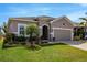Beautiful home with a lush green lawn and colorful landscaping, enhancing curb appeal at 13304 Magnolia Valley Dr, Clermont, FL 34711