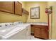 Laundry room features front loading washer and dryer, sink, cabinets and yellow walls at 13304 Magnolia Valley Dr, Clermont, FL 34711