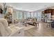 Open-concept living room with stylish furniture, hardwood floors, and abundant natural light at 13304 Magnolia Valley Dr, Clermont, FL 34711