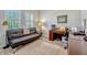 Office with a black futon couch and a dark wood desk situated under bright shuttered windows at 13304 Magnolia Valley Dr, Clermont, FL 34711