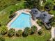 Aerial view of a community pool surrounded by palm trees and lounge chairs, offering a relaxing outdoor space at 13304 Magnolia Valley Dr, Clermont, FL 34711