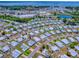 Aerial view of the property within a residential community; lake and shopping in the background at 1437 Apache Cir, Tavares, FL 32778