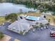 Stunning aerial perspective showcasing a community center, swimming pool, parking, and picturesque lakefront setting at 1437 Apache Cir, Tavares, FL 32778
