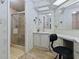 This bathroom features a glass shower, a vanity area, a sink with storage, and ample lighting at 1437 Apache Cir, Tavares, FL 32778