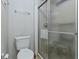 This bathroom features a toilet, a glass shower, a towel rack, and wallpaper at 1437 Apache Cir, Tavares, FL 32778