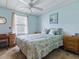 Tranquil bedroom with natural light, complemented by a ceiling fan at 1437 Apache Cir, Tavares, FL 32778