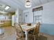 Bright dining area with adjacent kitchen, featuring white walls and furniture at 1437 Apache Cir, Tavares, FL 32778