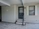 Close-up of the home's side entrance with steps, railing, and a storm door at 1437 Apache Cir, Tavares, FL 32778