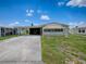 Well-maintained single-story home featuring an attached carport and manicured lawn at 1437 Apache Cir, Tavares, FL 32778