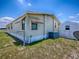 Exterior shot of the home with a small shed, AC unit, chain link fence, and awning at 1437 Apache Cir, Tavares, FL 32778