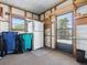 Spacious garage with a window, refrigerator, storage shelves, and rolling trash and recycling bins at 1437 Apache Cir, Tavares, FL 32778