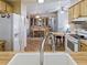 Well-lit kitchen showcasing a sink with wood-toned cabinets and a glimpse of the dining area at 1437 Apache Cir, Tavares, FL 32778