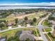 Aerial view of a residential area near a golf course and a serene lake at 1473 Lakemist Ln, Clermont, FL 34711